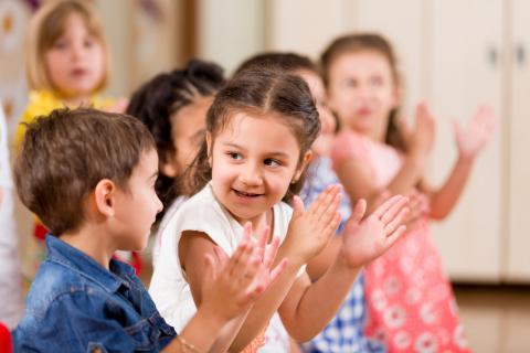 Group of preschool aged children clapping.