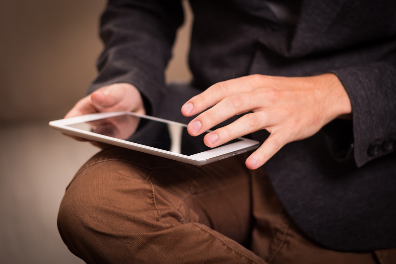 Man balancing ipad on his knee