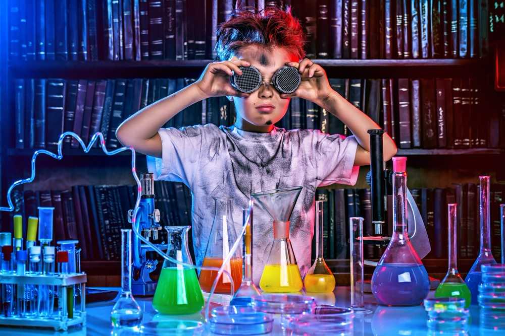 Young boy with goggles in front of a chemistry set