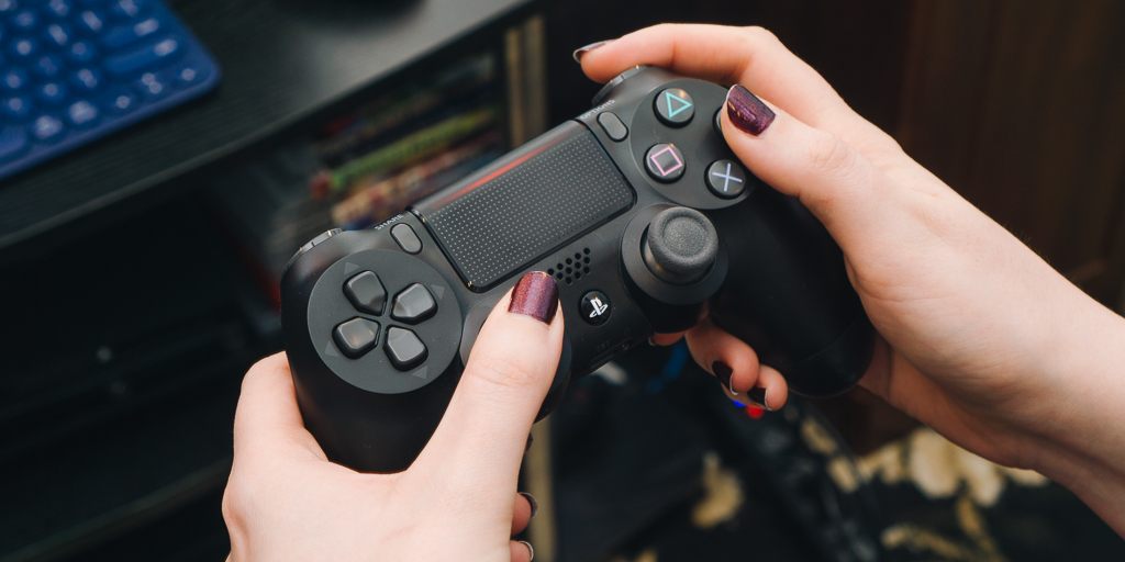 Hands holding and playing a video game controller