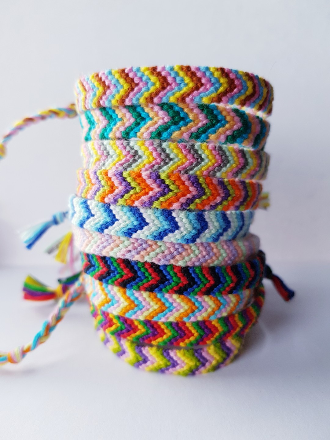 a stack of multicolored friendship bracelets