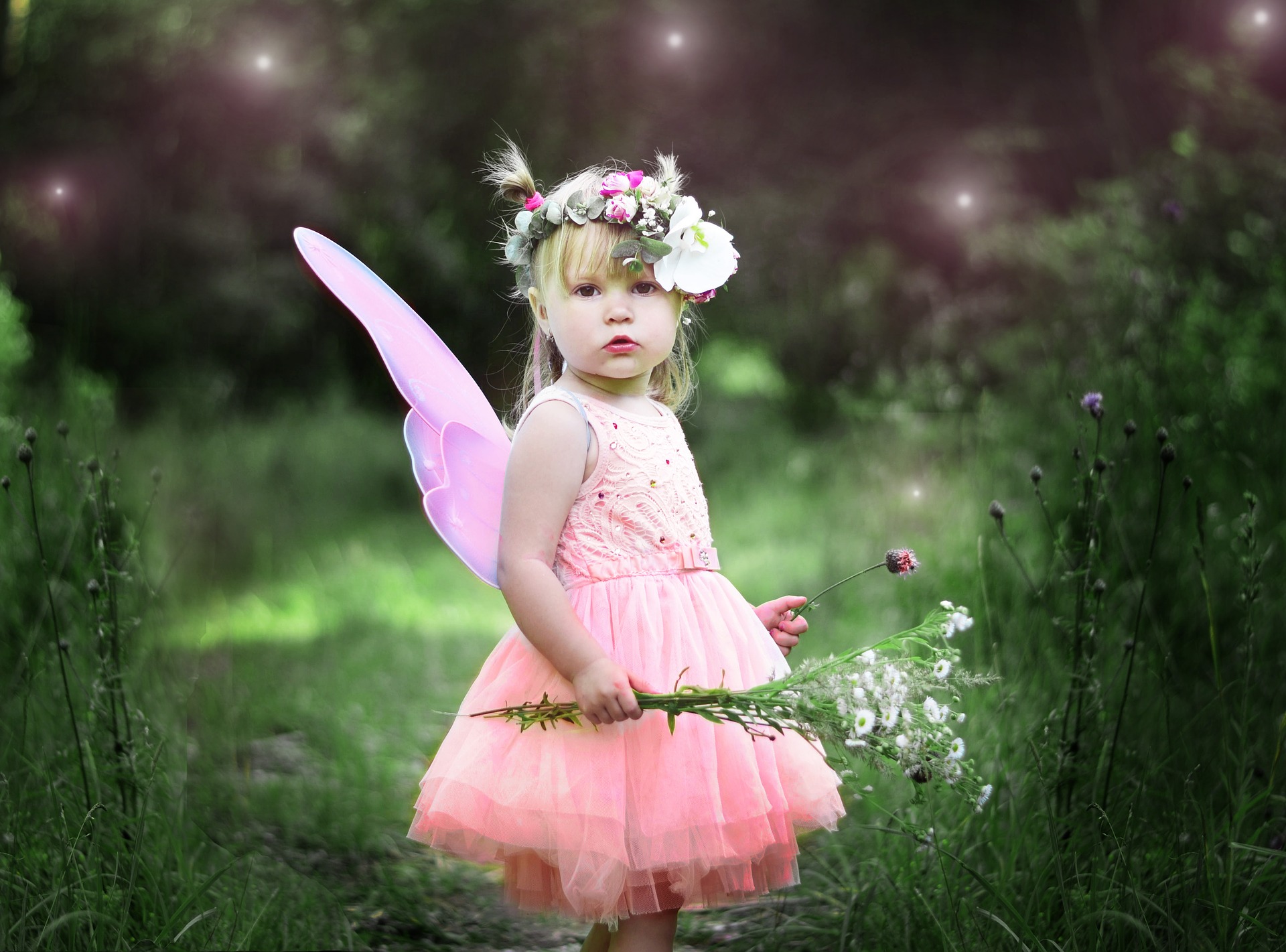 Toddler dressed as a fairy against a nature background