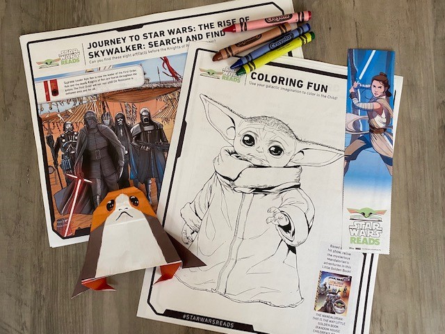 Baby Yoda coloring sheet, a Star Wars seek and find sheet, an origami Porg, a book mark and some crayons that come in the Take & Make kit 