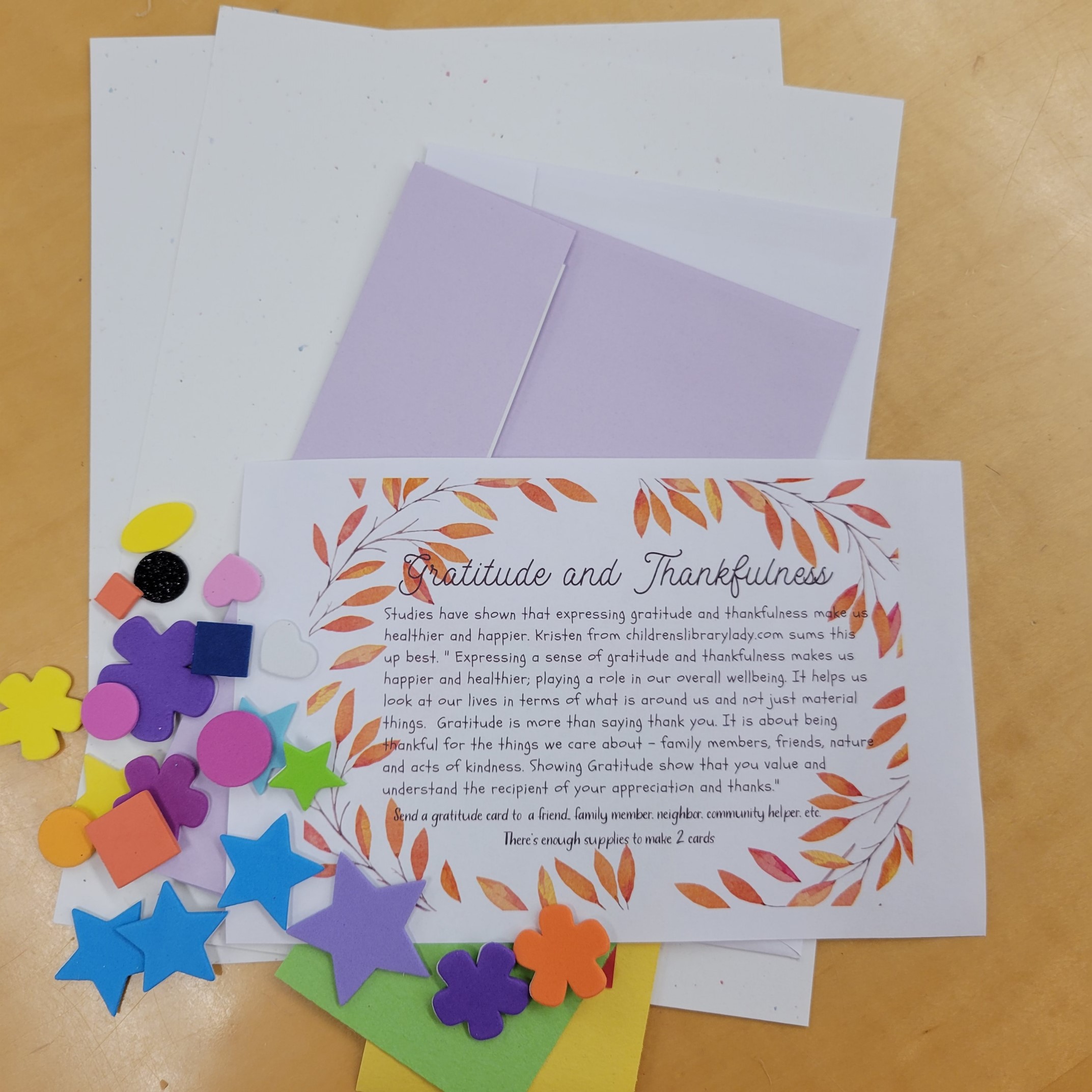 flat lay of cardstock, envelopes, foam shape stickers, and craft instructions