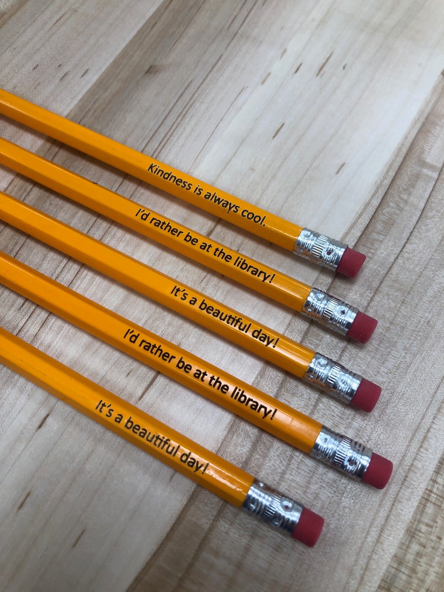 yellow wooden pencils with phrases engraved on them