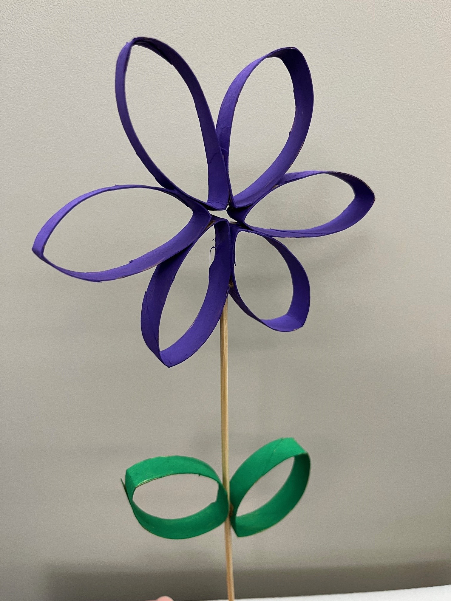 purple flower with green leaves made out of cardboard