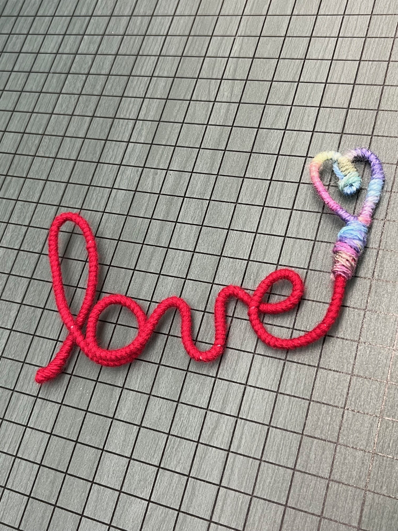 the word love written in script and wrapped with yarn