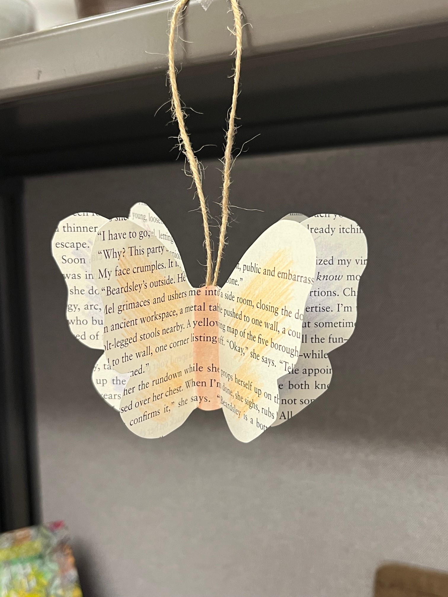 butterfly shape made from book page hanging on a twine loop