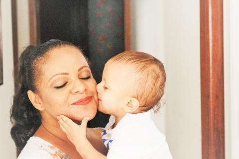 Little baby kissing its mother's cheek