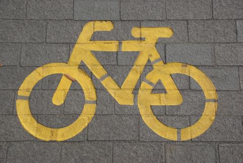 bicycle safety sign painted yellow on street