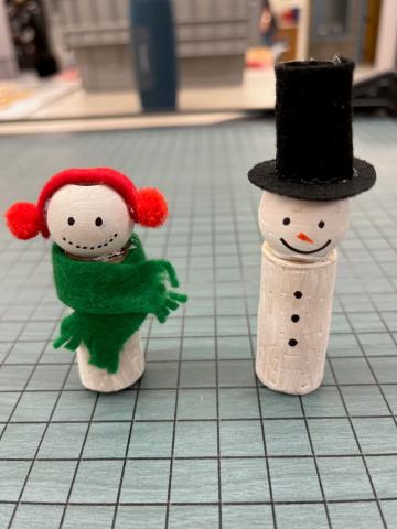 two snow people made from cork and felt