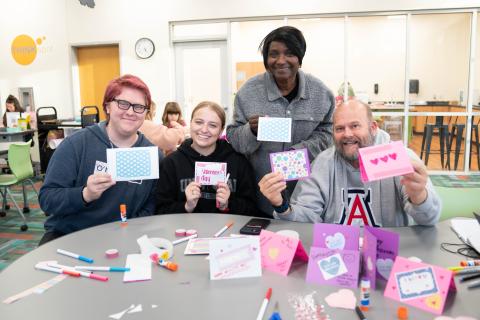 four patrons holding handmade valentine's cards