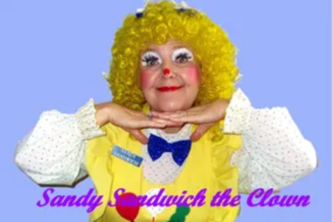 Clown with curly yellow hair and bright painted face