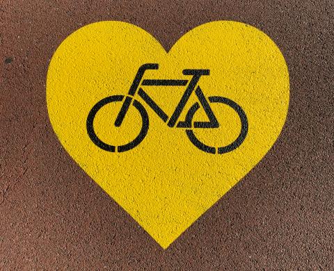 yellow heart painted on ground with black bike outline in the middle