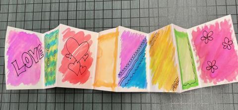 paper booklet painted with watercolors and adorned with line drawings