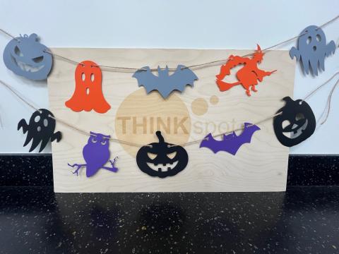 pumpkins, bats, ghosts, and owls cut out of paper in orange, grey, black and purple