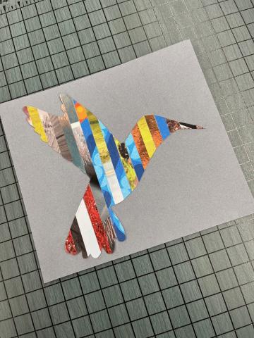 hummingbird silhouette made of strips of magazine paper