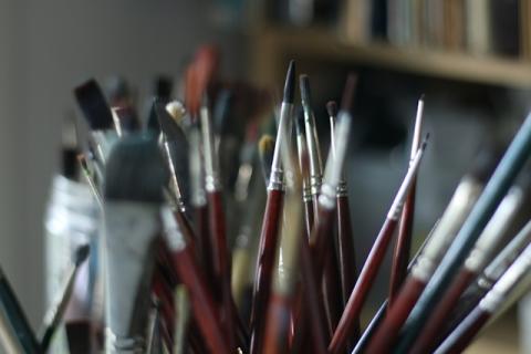 A cup full of small paint brushes.