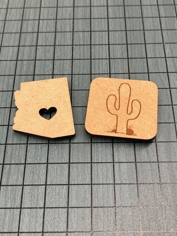 wooden square with engraved cactus and wooden piece in the outline of Arizona