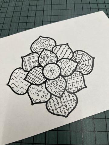 black and white flower with geometric designs in each petal