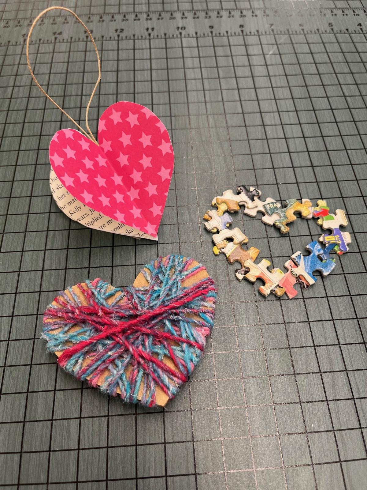 three hearts, one is 3 dimensional, one is wrapped in yarn, one is made out of puzzle pieces