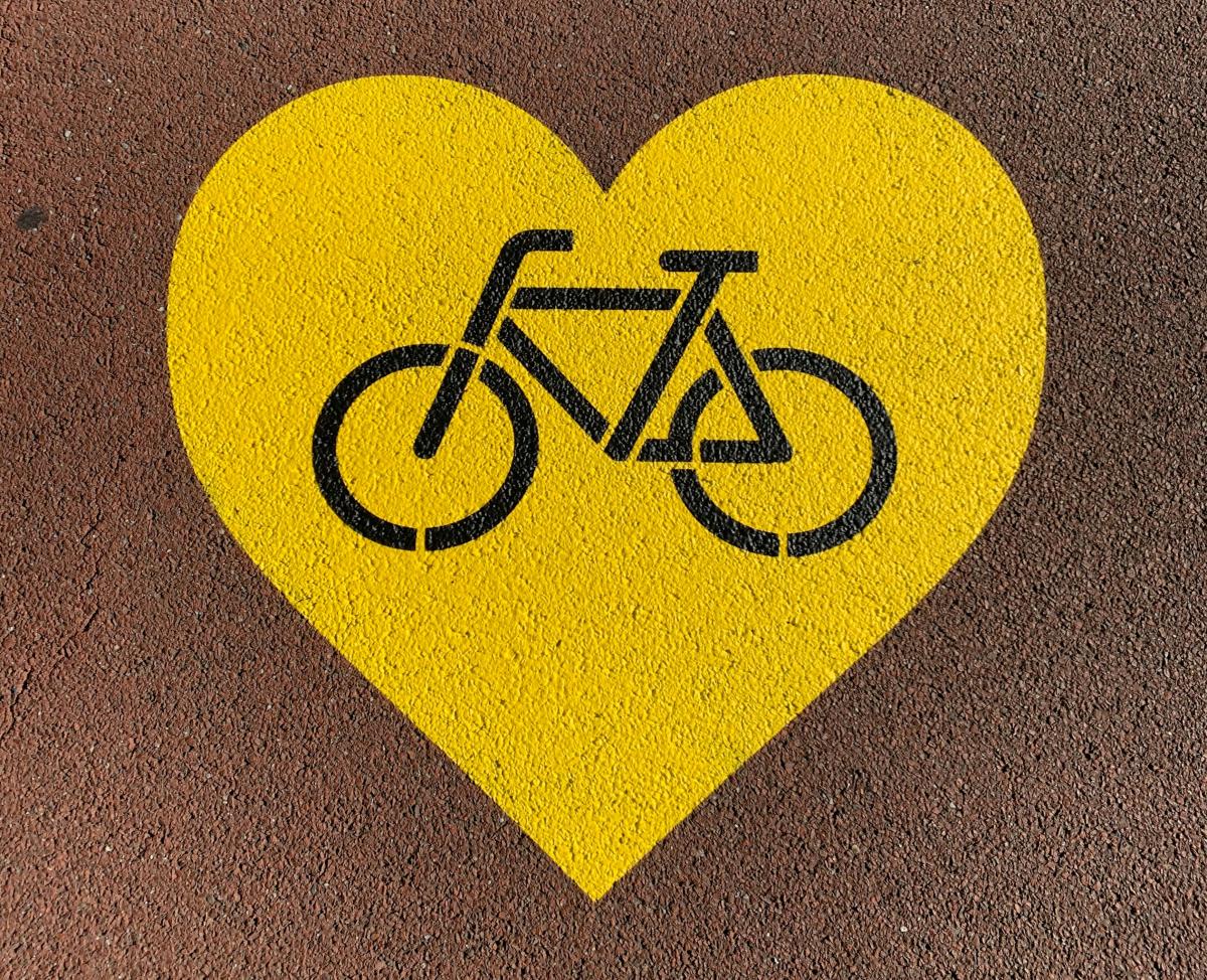 yellow heart painted on ground with black bike outline in the middle