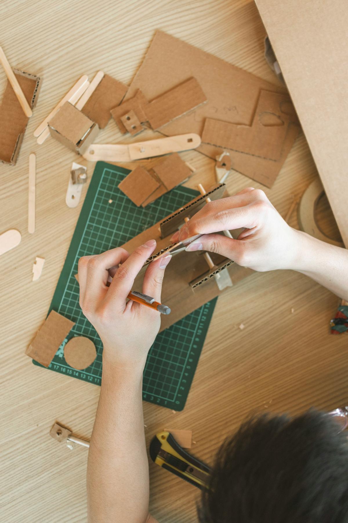 A person using cardboard to make a craft.