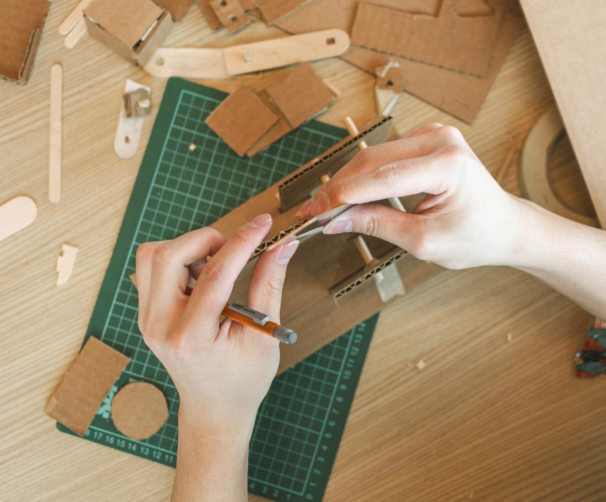 A person using cardboard to make a craft.