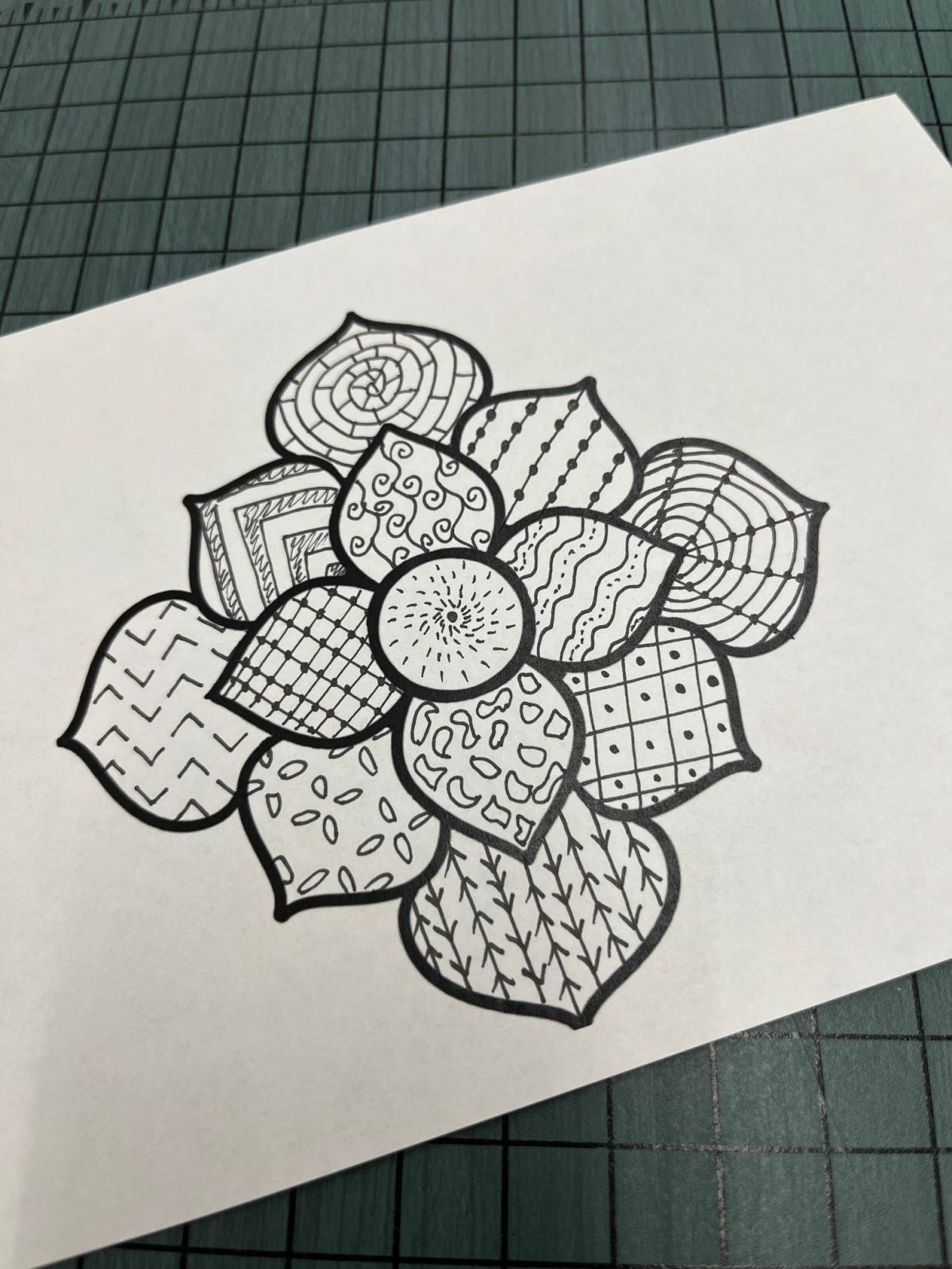 black and white flower with geometric designs in each petal